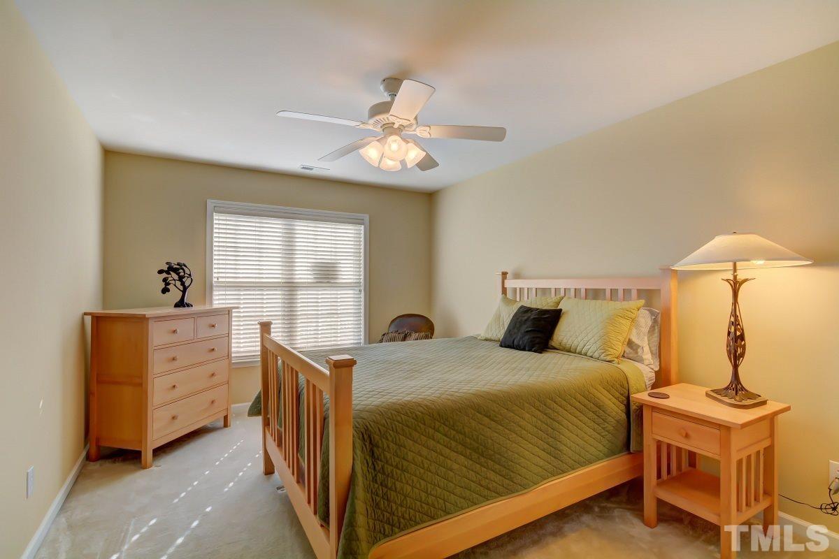 3902 Sunset Maple Court Raleigh, NC 27612 - Photo 17 of 21 a bedroom with a bed and a chandelier