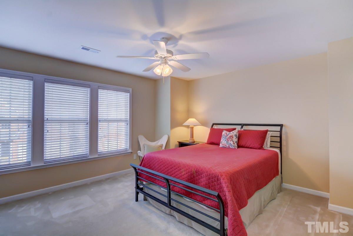 3902 Sunset Maple Court Raleigh, NC 27612 - Photo 18 of 21 a bedroom with a bed and a chandelier