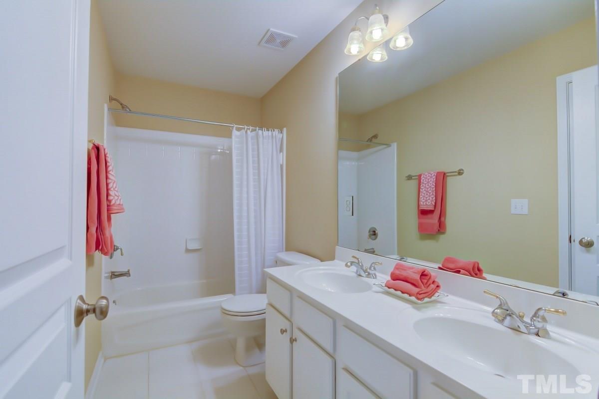 3902 Sunset Maple Court Raleigh, NC 27612 - Photo 19 of 21 a bathroom with a sink vanity mirror and toilet