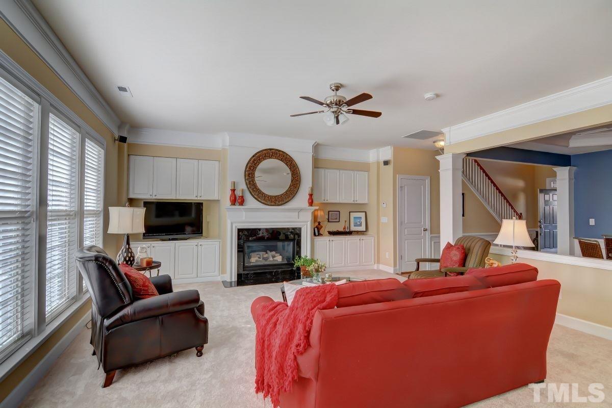 3902 Sunset Maple Court Raleigh, NC 27612 - Photo 5 of 21 a living room with furniture a fireplace and a large window