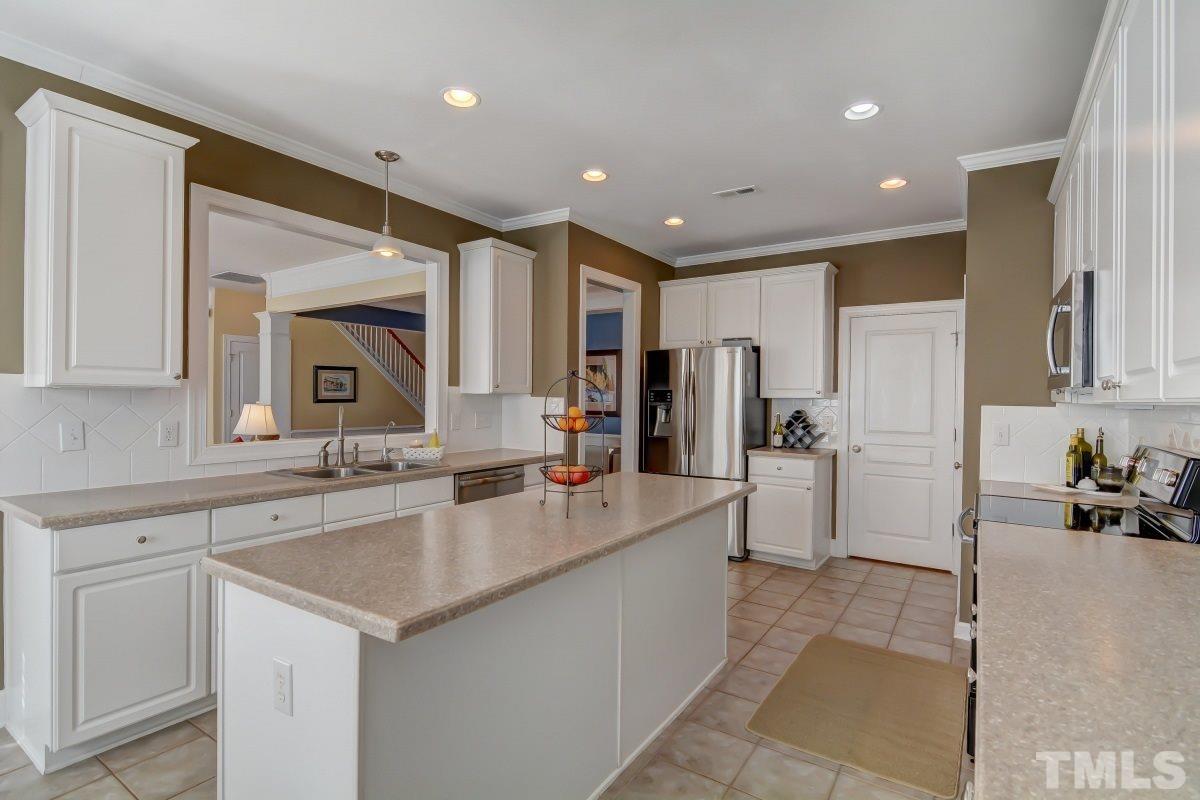 3902 Sunset Maple Court Raleigh, NC 27612 - Photo 8 of 21 a large kitchen with kitchen island a sink appliances and cabinets