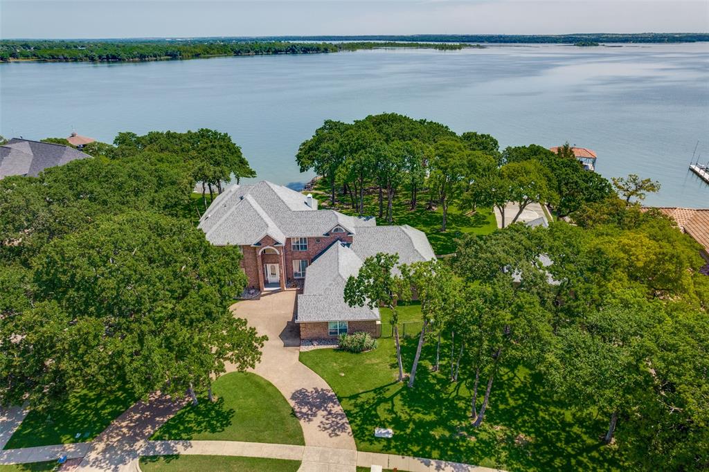 452 Windjammer Lane Azle, TX 76020 - Photo 2 of 40 a view of a lake with lawn chairs and large trees