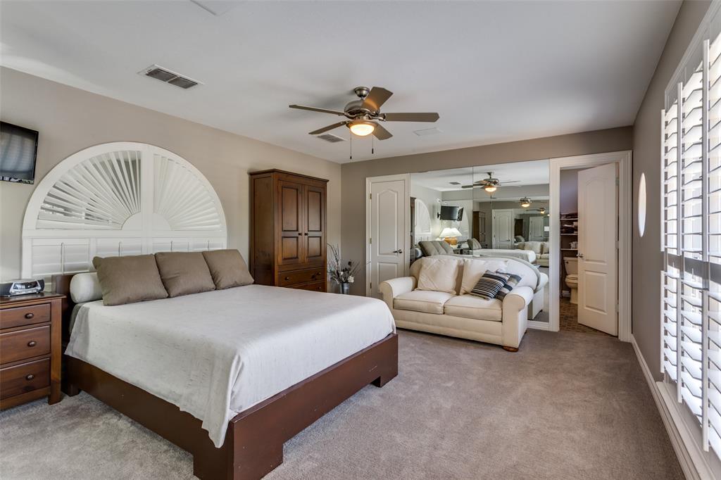 452 Windjammer Lane Azle, TX 76020 - Photo 25 of 40 a bedroom with a large bed and a chandelier