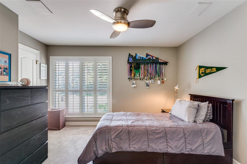 452 Windjammer Lane Azle, TX 76020 - Photo 26 of 40 a bedroom with a bed and a chandelier