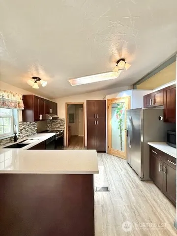 a large kitchen with a stove a sink and a refrigerator