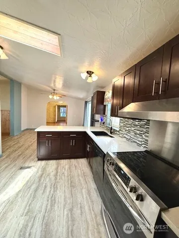 a large kitchen with kitchen island granite countertop a sink stove and refrigerator