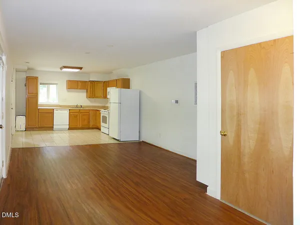 a view of a kitchen with a fridge and wooden floor