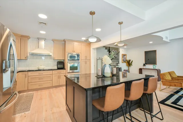 a kitchen with kitchen island granite countertop a table chairs microwave and cabinets
