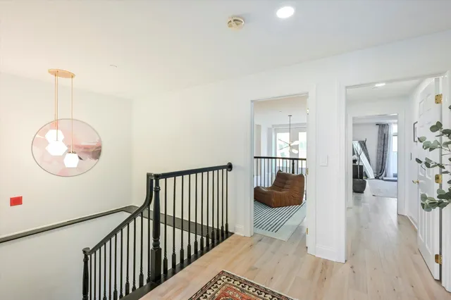 a view of a hallway to room with wooden floor