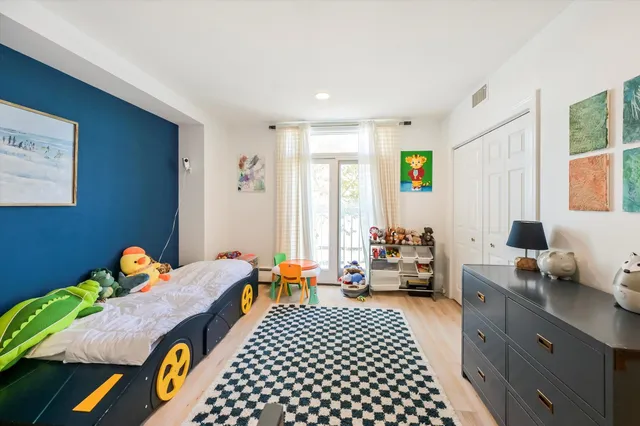 a bedroom with a bed and wooden floor