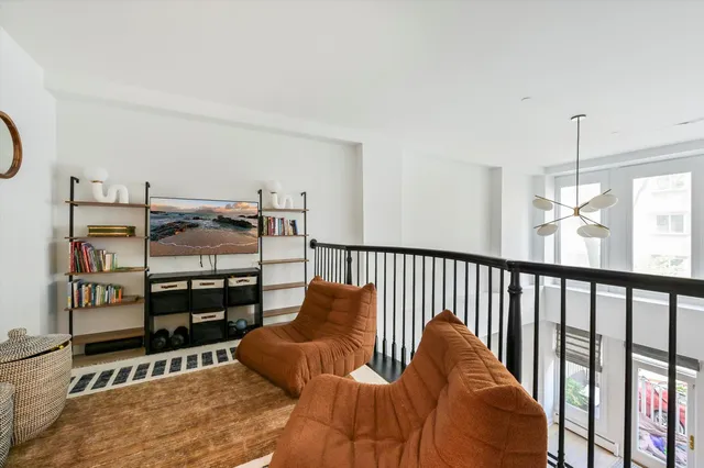 a living room with furniture a ceiling fan and a wooden floor