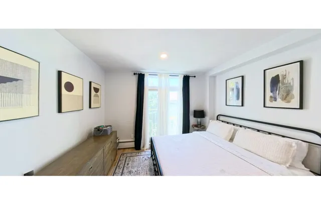 a bedroom with a bed and a painting on the wall