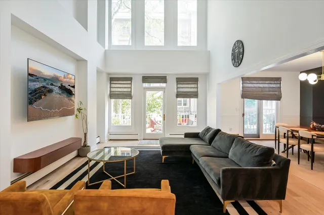 a living room with furniture and floor to ceiling windows