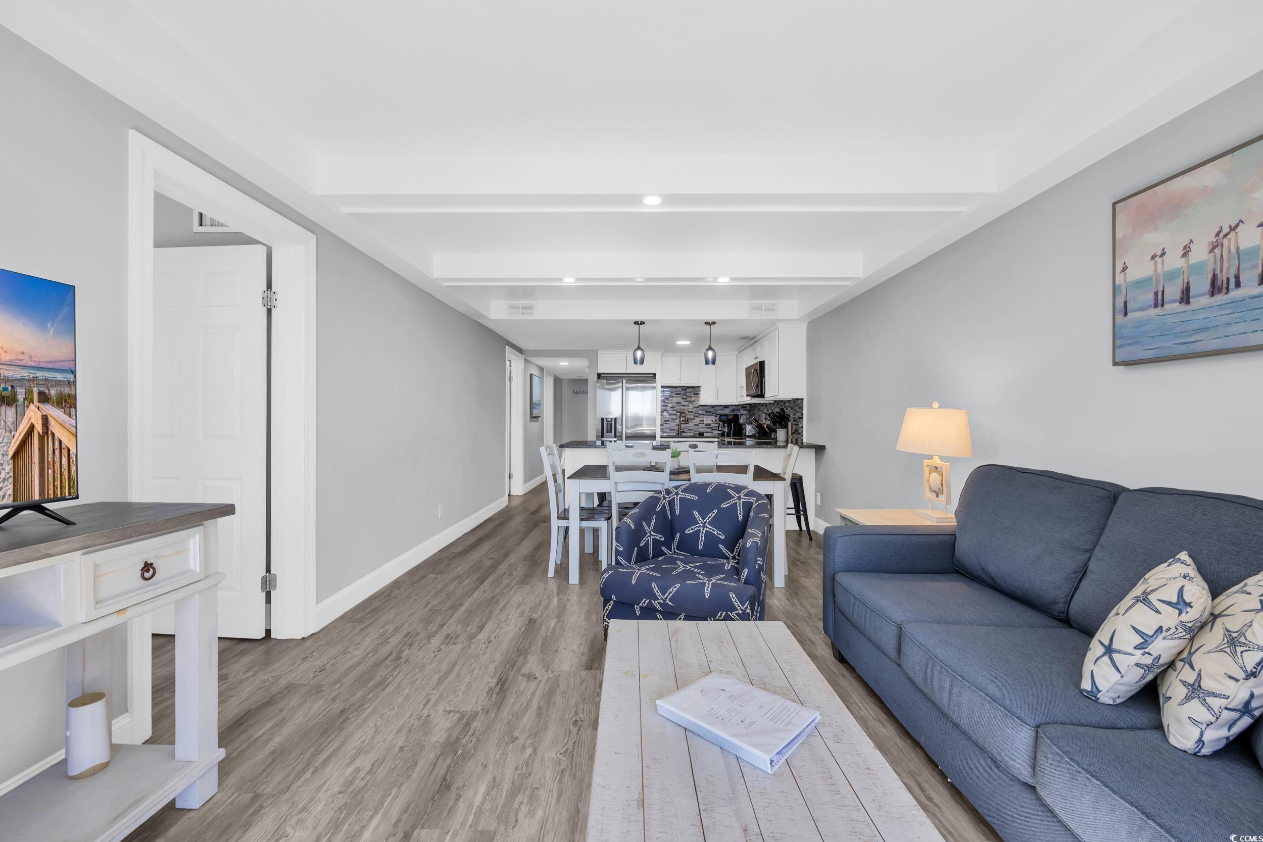 601 Mitchell Drive, Unit 203 Myrtle Beach, SC 29577 - Photo 15 of 40 Living area with wood finished floors and beamed ceiling