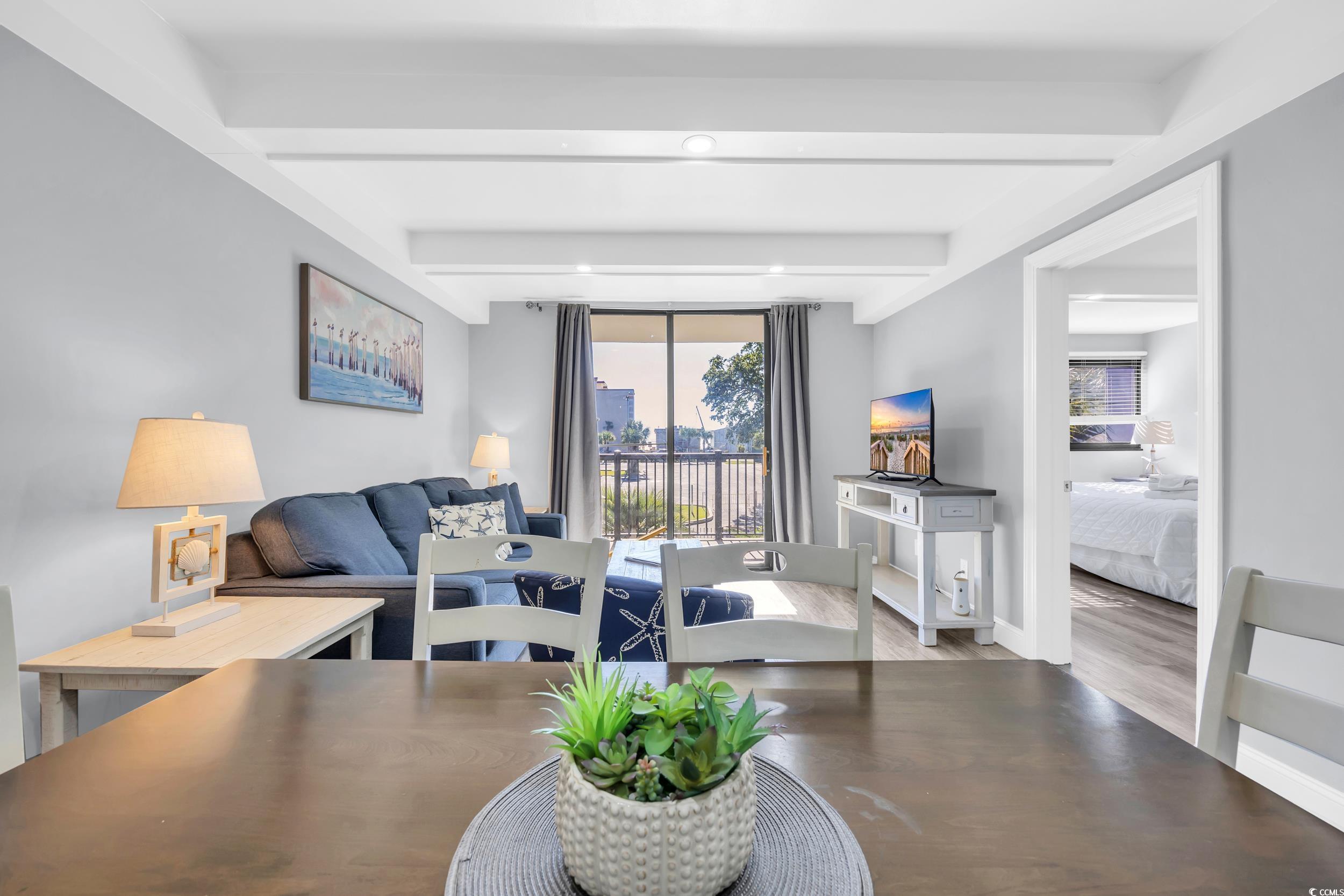 601 Mitchell Drive, Unit 203 Myrtle Beach, SC 29577 - Photo 17 of 40 Living room with wood finished floors and beam ceiling
