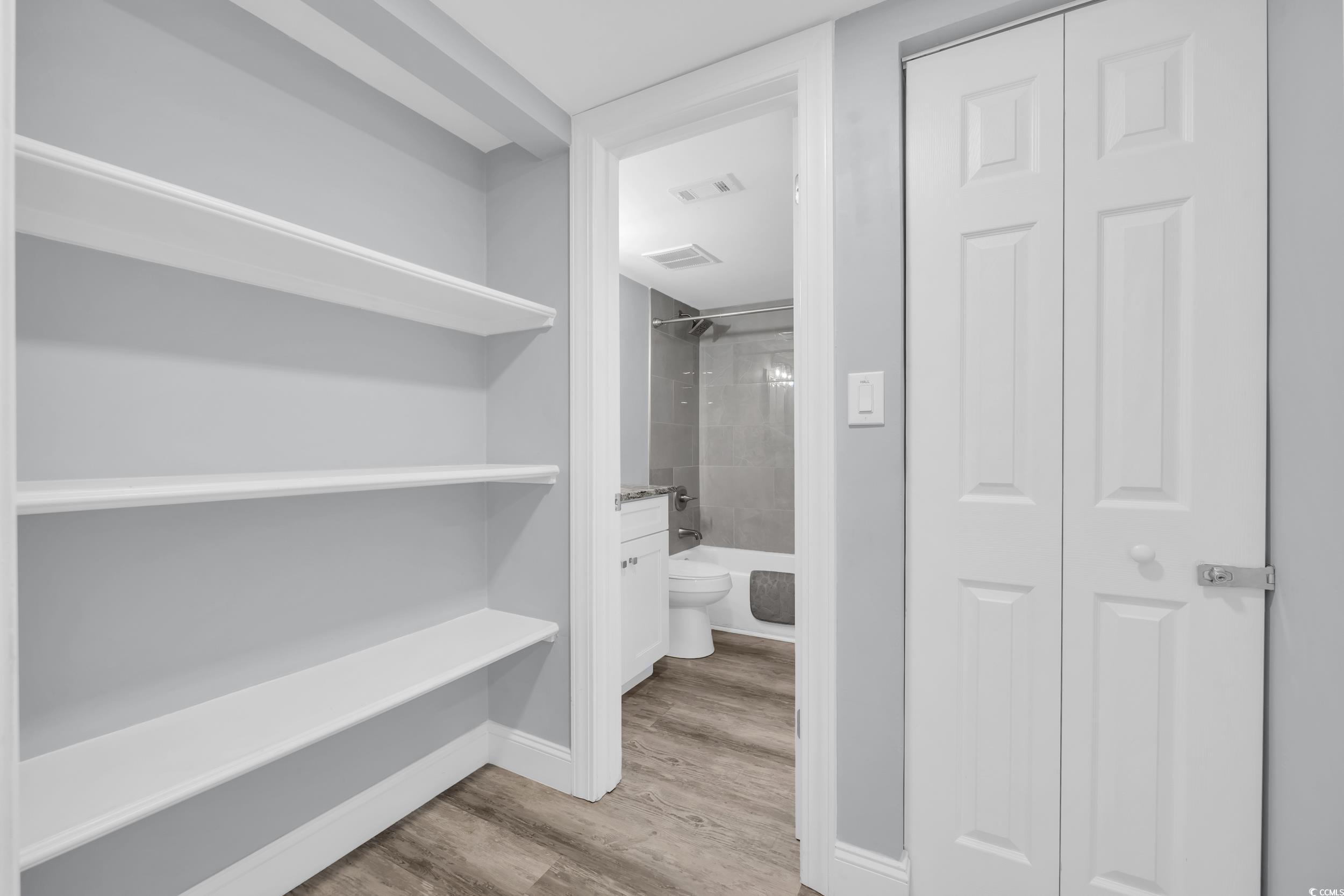 601 Mitchell Drive, Unit 203 Myrtle Beach, SC 29577 - Photo 5 of 40 Bathroom featuring a closet, tub / shower combination, and light wood finished floors