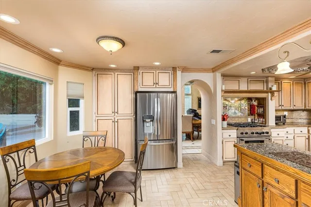 a kitchen with stainless steel appliances granite countertop a refrigerator and a stove top oven