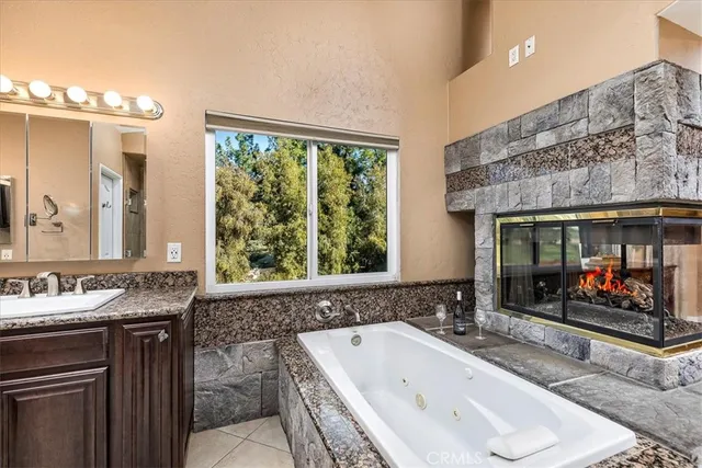 a bathroom with a tub sink and mirror
