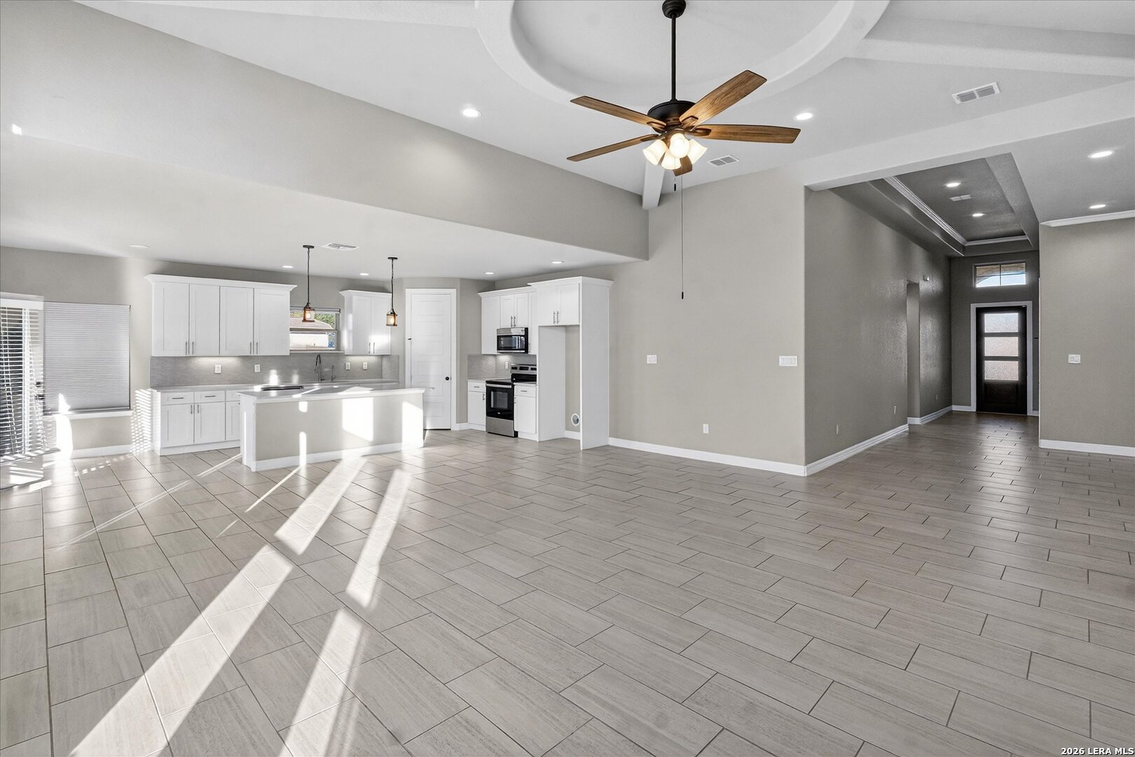 132 West Medium Meadow Drive Lytle, TX 78052 - Photo 11 of 40 a view of a living room a ceiling fan and kitchen view