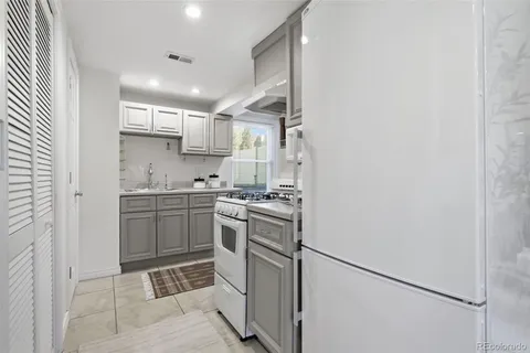 a kitchen with a sink cabinets stainless steel appliances and a window