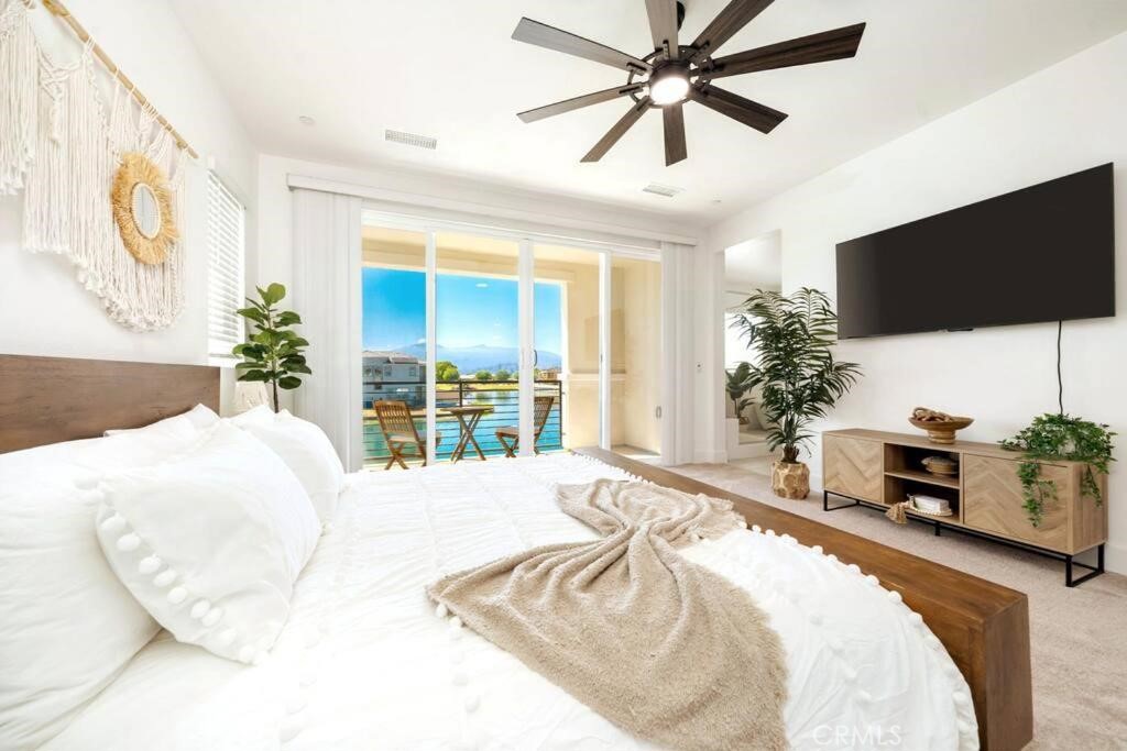 84675 Lago Brezza Indio, CA 92203 - Photo 19 of 40 a bedroom with a bed a flat screen tv and a potted plant