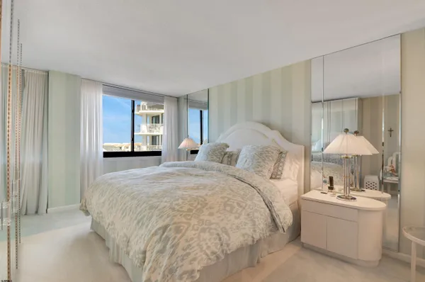 a bedroom with a large bed and a chandelier