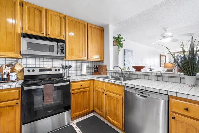 a kitchen with stainless steel appliances granite countertop a stove a sink and a microwave