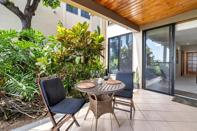 a view of a patio with a table and chairs and potted plants