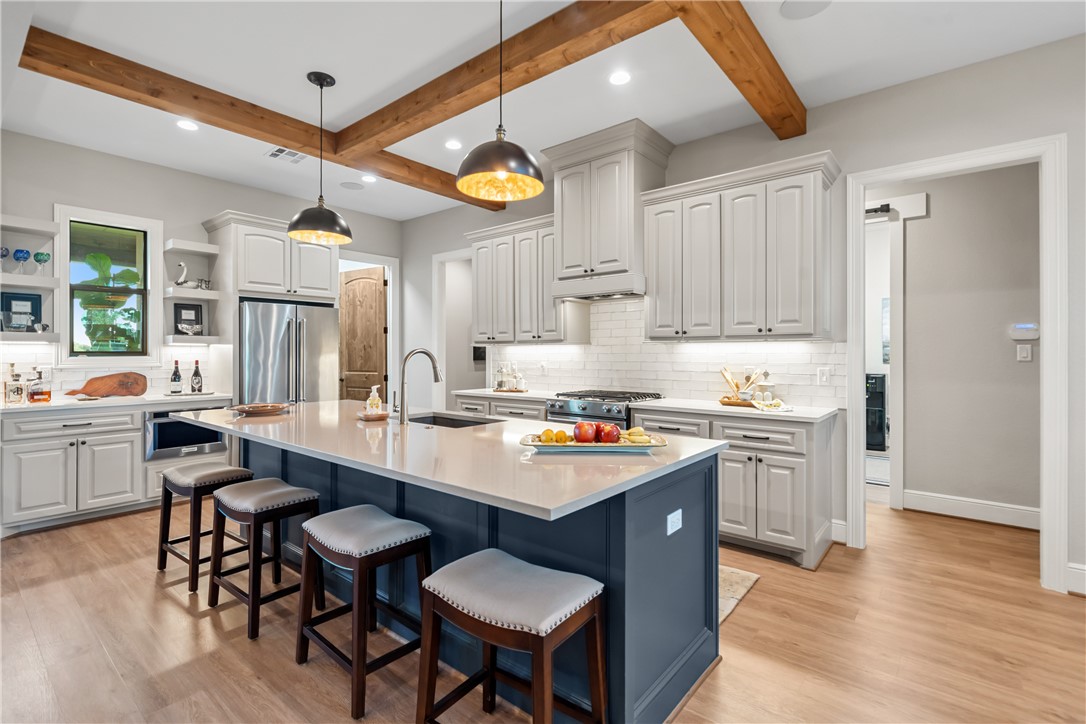 30163 High Spirit Ranch Road Hempstead, TX 77445 - Photo 14 of 49 Kitchen featuring beam ceiling, open shelves, tasteful backsplash, a kitchen breakfast bar, and light wood-style floors