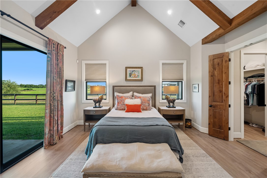 30163 High Spirit Ranch Road Hempstead, TX 77445 - Photo 19 of 49 Bedroom featuring beam ceiling, light wood finished floors, high vaulted ceiling, and a walk in closet