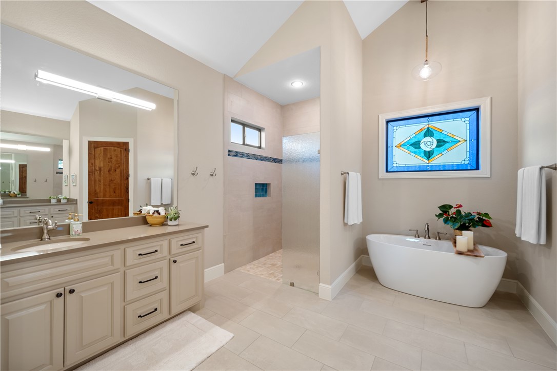 30163 High Spirit Ranch Road Hempstead, TX 77445 - Photo 22 of 49 Bathroom featuring lofted ceiling, a walk in shower, a soaking tub, vanity, and tile patterned floors