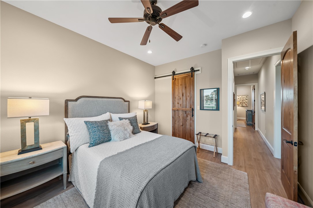 30163 High Spirit Ranch Road Hempstead, TX 77445 - Photo 30 of 49 Bedroom featuring a barn door, recessed lighting, wood finished floors, and ceiling fan