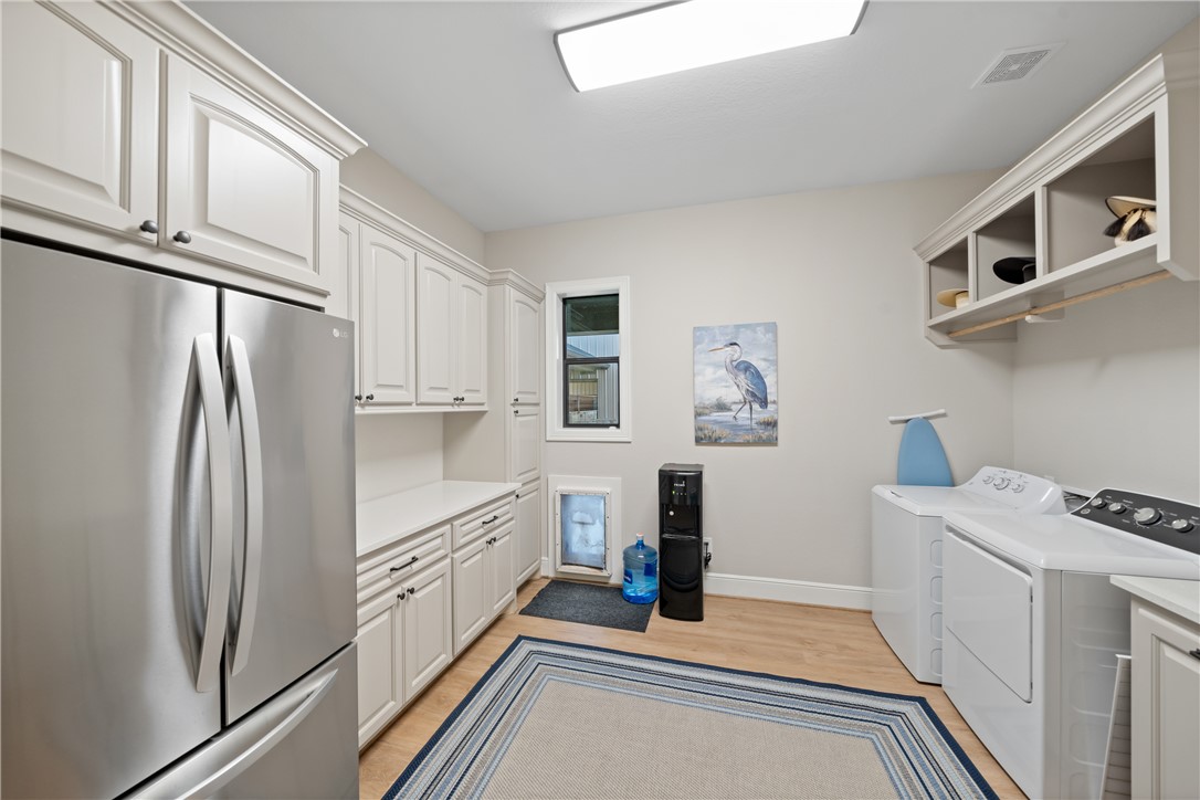30163 High Spirit Ranch Road Hempstead, TX 77445 - Photo 36 of 49 Laundry area featuring cabinet space, washer and dryer, and light wood-style flooring