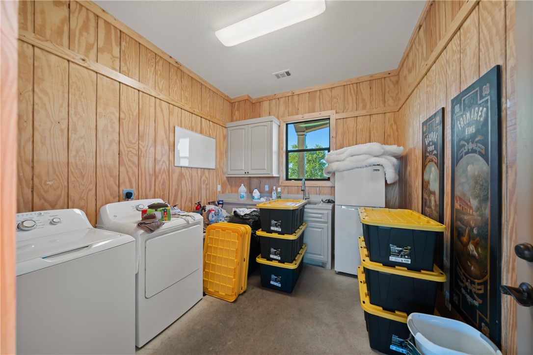 30163 High Spirit Ranch Road Hempstead, TX 77445 - Photo 46 of 49 Washroom featuring washer and dryer, cabinet space, and wood walls