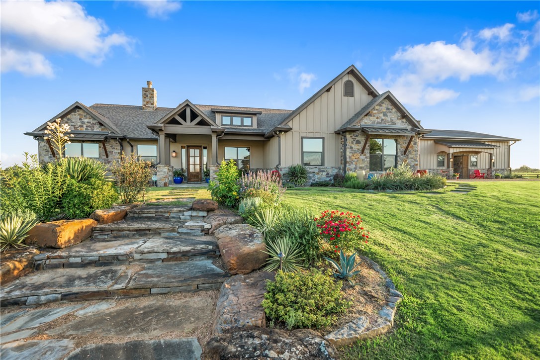 30163 High Spirit Ranch Road Hempstead, TX 77445 - Photo 5 of 49 Craftsman house with stone siding, board and batten siding, a front lawn, and a chimney