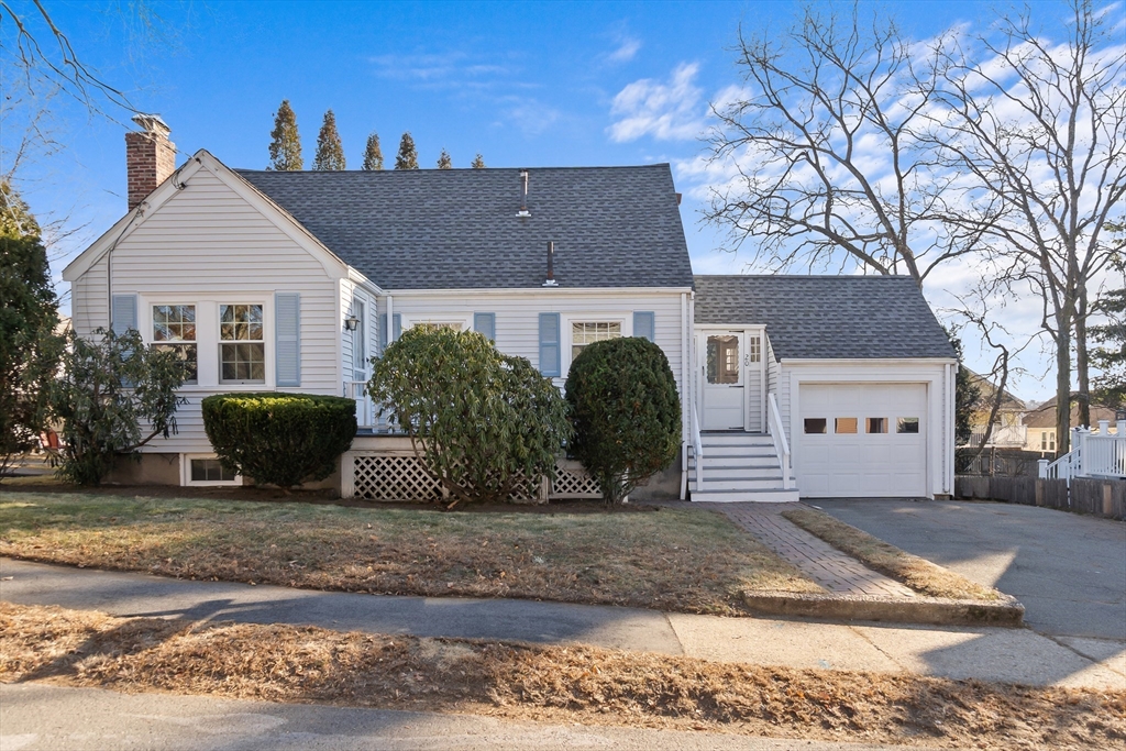 a view of a house with a yard and large tree