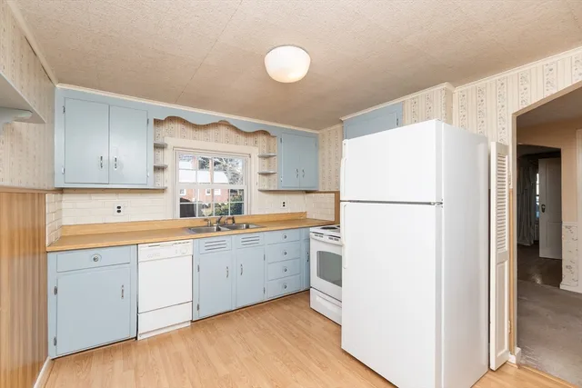 a kitchen with a refrigerator sink stove and cabinets