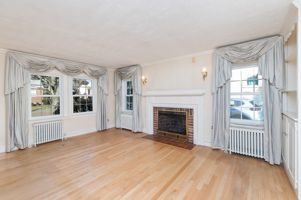20 Rosedale Road Watertown, MA 02472 - Photo 7 of 21 wooden floor fireplace and windows in an empty room