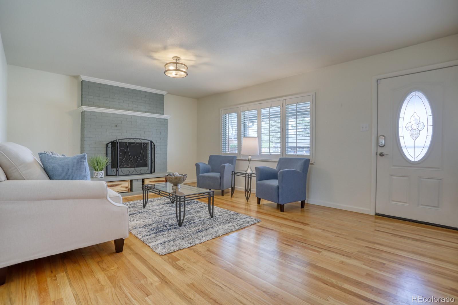 1465 South Vancouver Court Lakewood, CO 80228 - Photo 6 of 31 a living room with furniture a fireplace and a flat screen tv