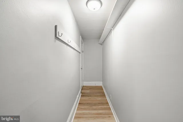 a view of a hallway with wooden floor and entryway