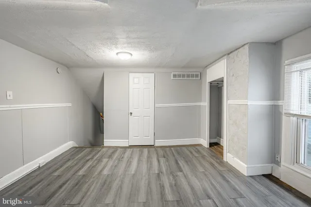 a view of empty room with wooden floor