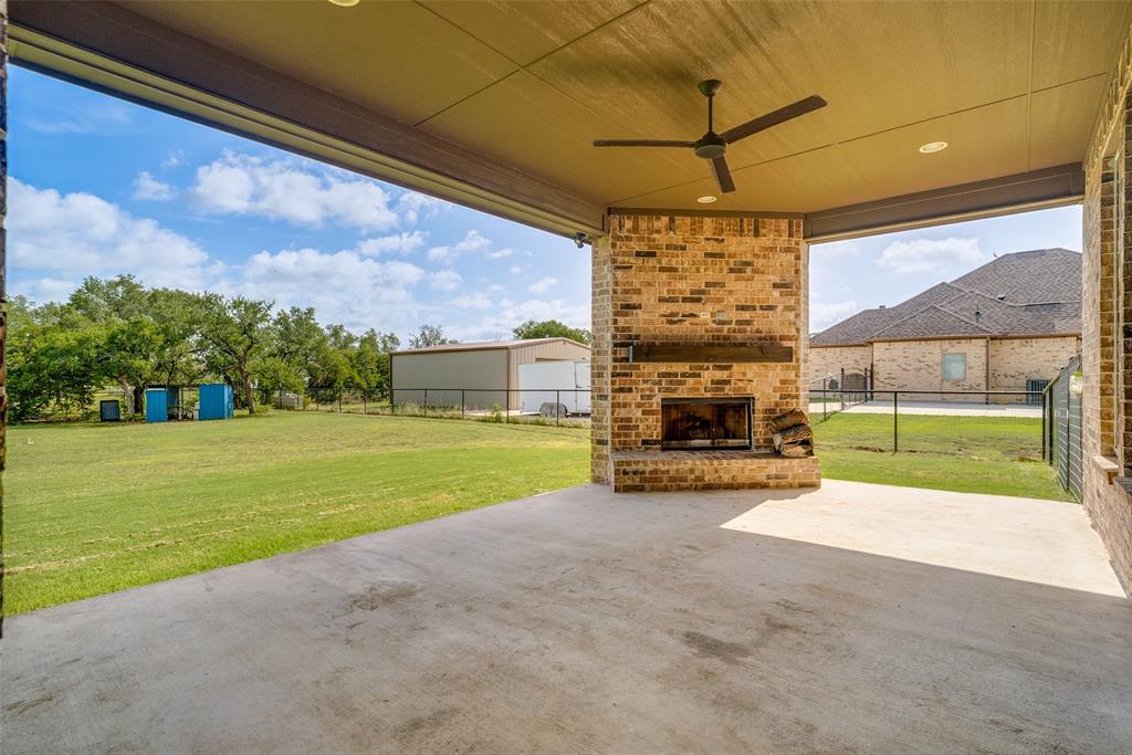 6913 Veal Station Road Weatherford, TX 76085 - Photo 25 of 31 Covered outdoor living space featuring a brick fireplace with a wood mantle, a ceiling fan, and recessed lighting