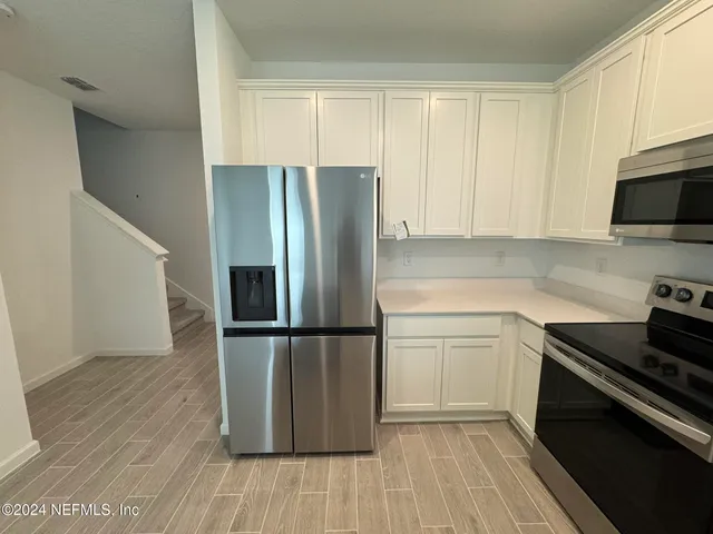 a kitchen with a refrigerator stove and wooden cabinets