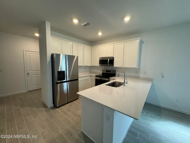a kitchen with kitchen island a refrigerator sink and microwave