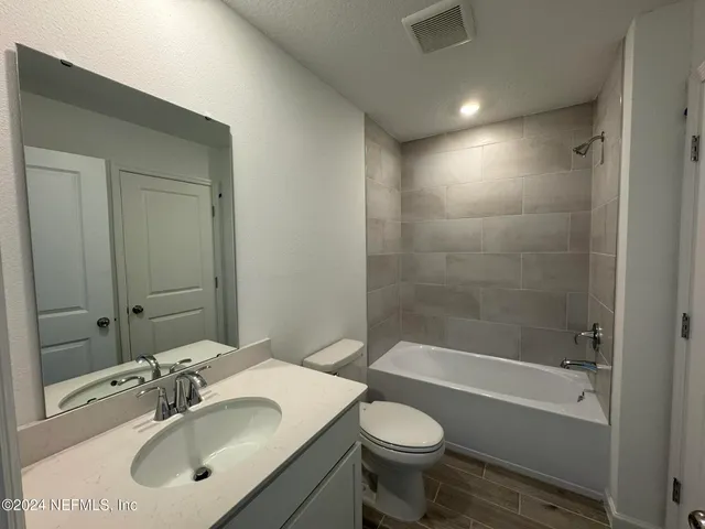 a bathroom with a sink mirror toilet and bathtub