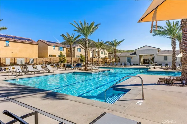 a view of yard with swimming pool and table and chairs under an umbrella