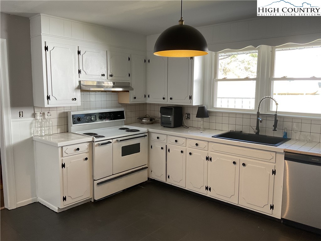 4560 Highway 18 Sparta, NC 28675 - Photo 17 of 43 a kitchen with granite countertop white cabinets white appliances with a sink and dishwasher
