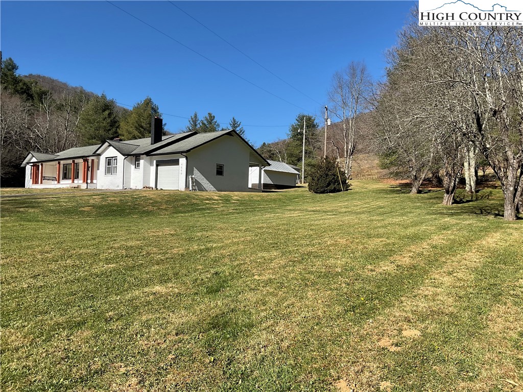 4560 Highway 18 Sparta, NC 28675 - Photo 6 of 43 a white house that has a big yard with plants and trees