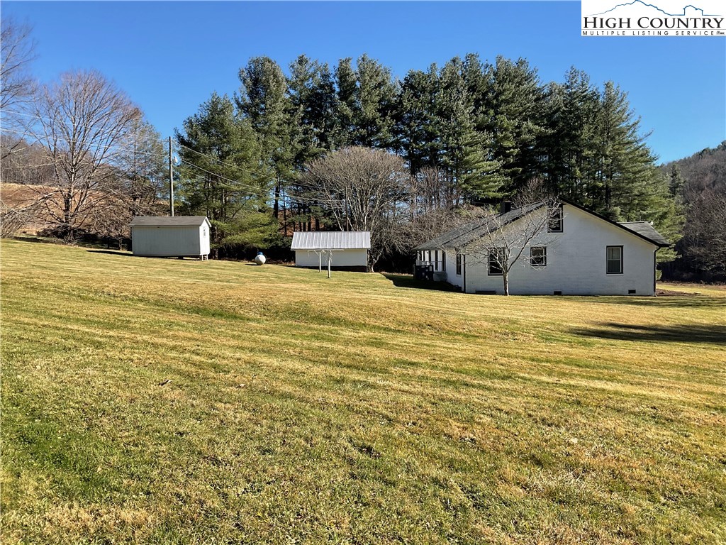 4560 Highway 18 Sparta, NC 28675 - Photo 10 of 43 a swimming pool that has lawn chairs with wooden fence