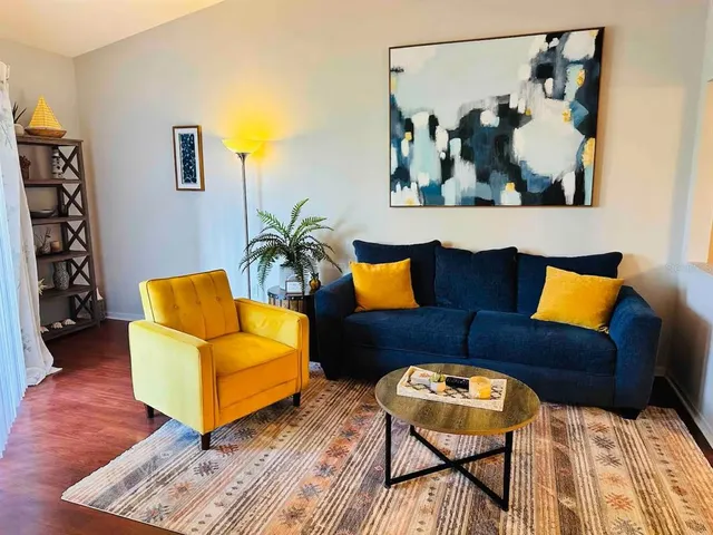 a living room with furniture and wooden floor